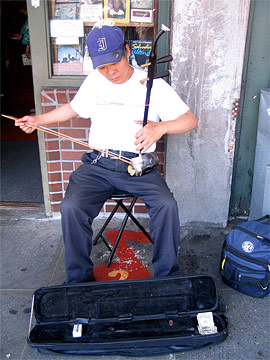 Chinese man playing strange instrument on the street
