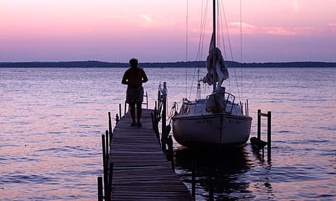 Man on pier beside Sailboat Man on pier beside Sailboat