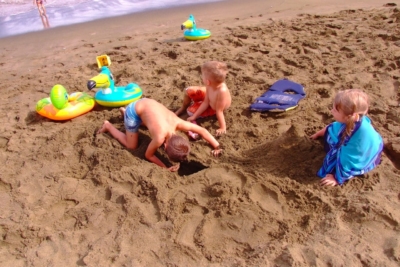 Kids playing in Mahana Bay green sand