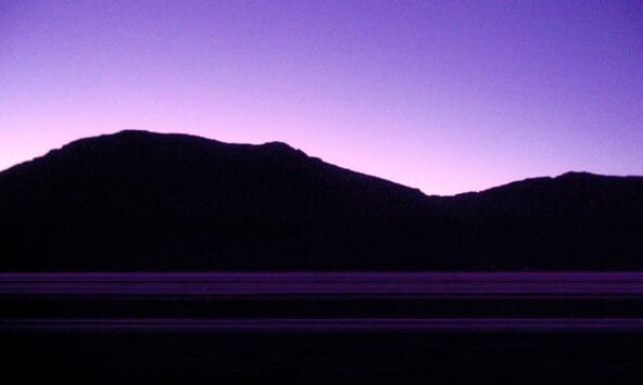 Dawnlight behind desert hills
