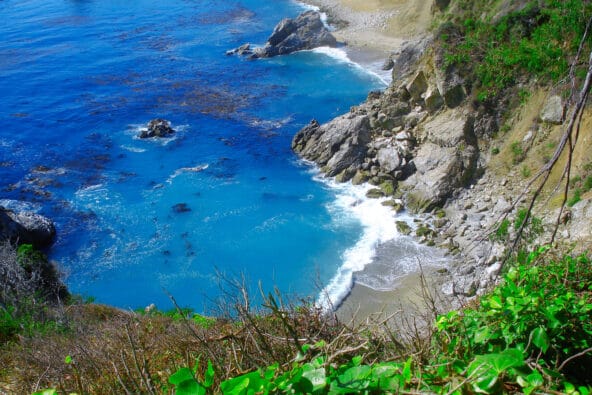 Looking down to tiny beach by bluegreen waters