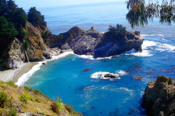 McWay Falls and a bluegreen bay below (wide shot)