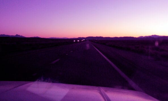 Orange dawnlight behind desert hills