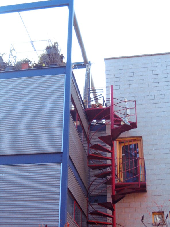 Red spiral staircase up to vertical house