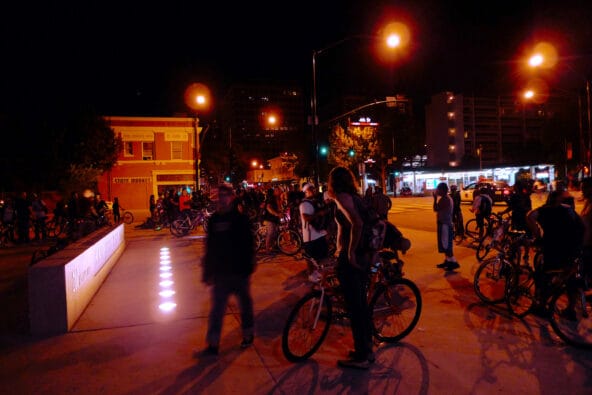 Silhouette of Bikers by San Jose City Hall sign