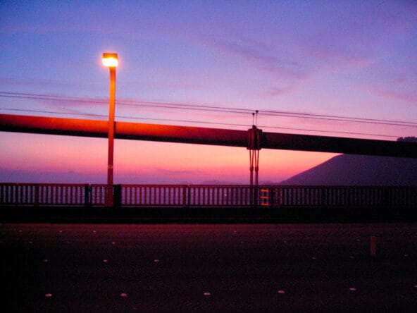 Sun setting behind bridge cables