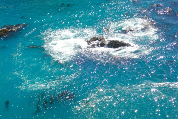 Water swirling in a bluegreen bay (superzoom)