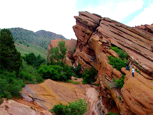 People atop a huge red sandstone formation People atop a huge red sandstone formation
