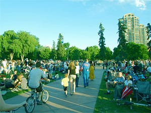 People walking past a huge picnic crowd