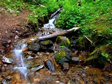 Small stream running over colorful pebbles (silky water)
